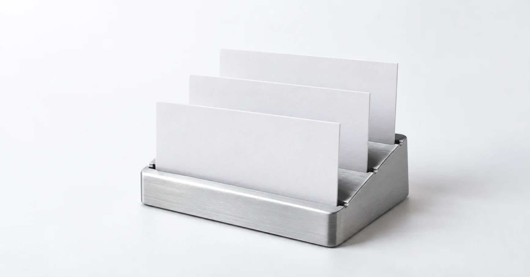 Tres tarjetas blancas organizadas en un pequeño soporte de aluminio.