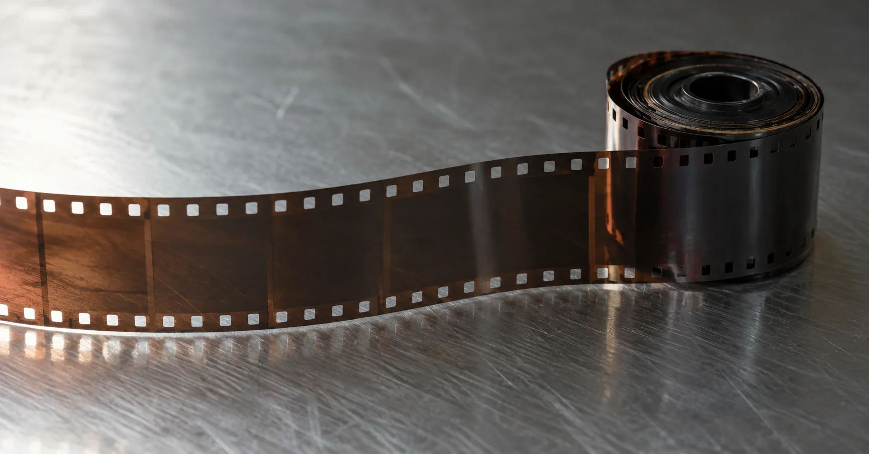 Un rollo de película fotográfica sobre una superficie de acero.