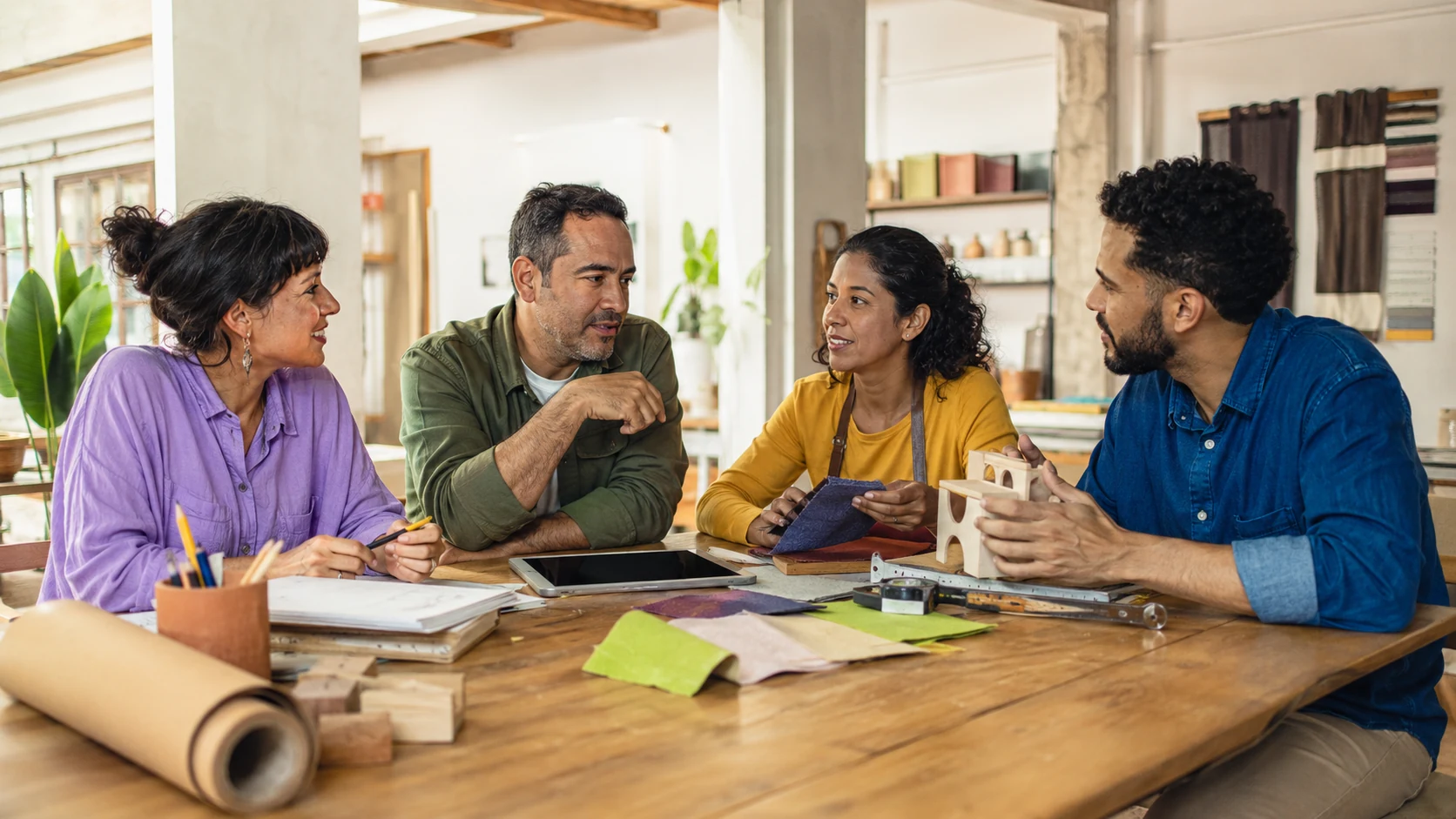 Personas de distintos oficios compartiendo tecnología alrededor de una mesa común
